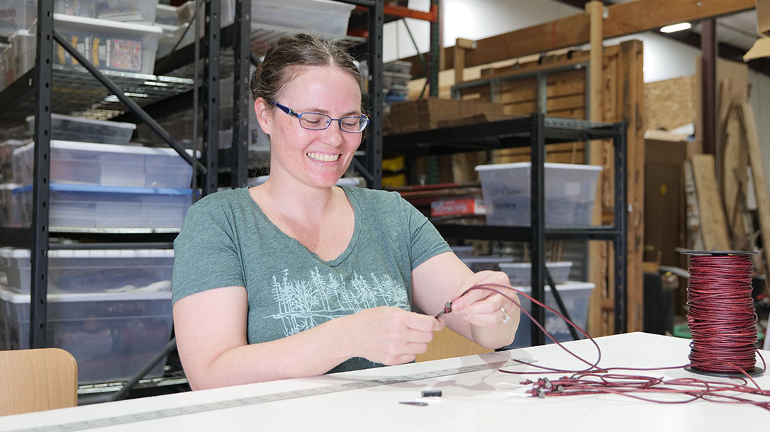 One of Wazoo’s artisan necklace tyers, a woman named Misty, who meticulously tie’s their signature survival necklaces.