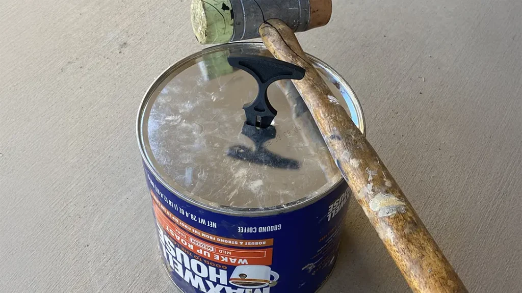 The author tested the G10 dagger by pounding it through the tinplate steel bottom of a coffee can.