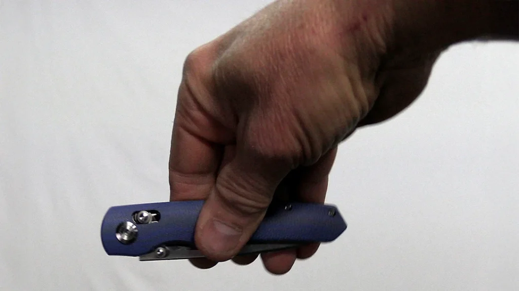 To perform a standard-grip inertial opening, grip the closed knife between your fingertips and thumb with your fingers extended and perpendicular to the knife’s handle.