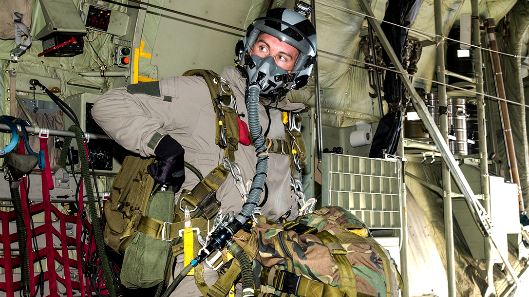 Travis Haley checking gear before a jump at high altitude.