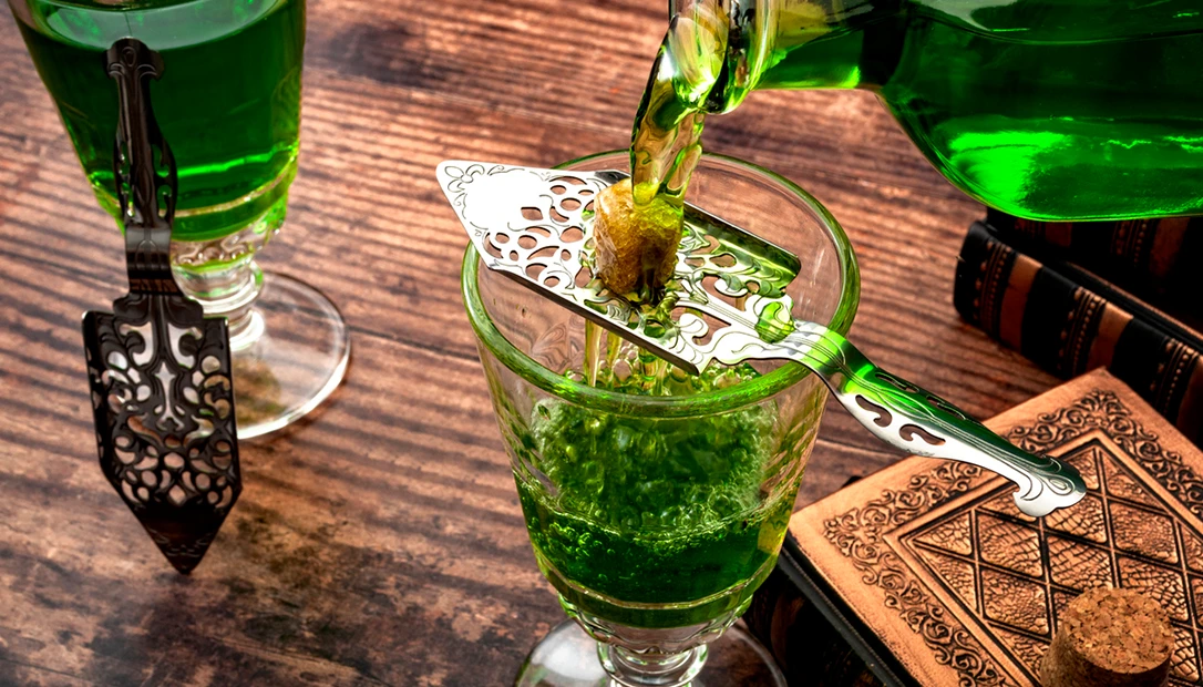Glass of absinthe with sugar cube and spoon.